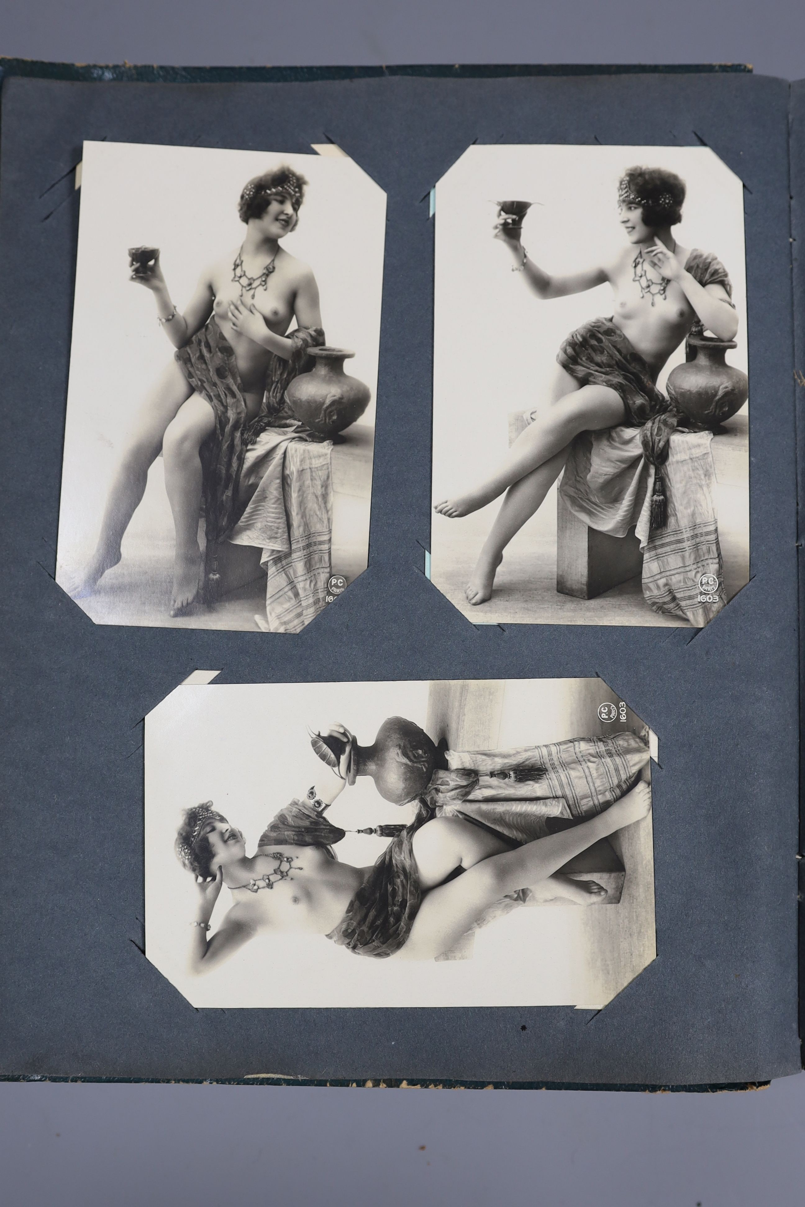 An Edwardian green postcard album, mounted with 68 risqué cards and a brown album mounted with Edwardian, George V and later, mainly topographical cards (2)